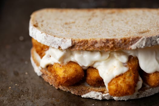 close up of rustic golden english fish fingers sandwich