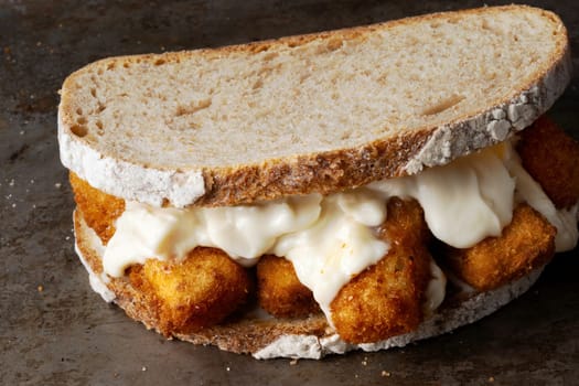 close up of rustic golden english fish fingers sandwich