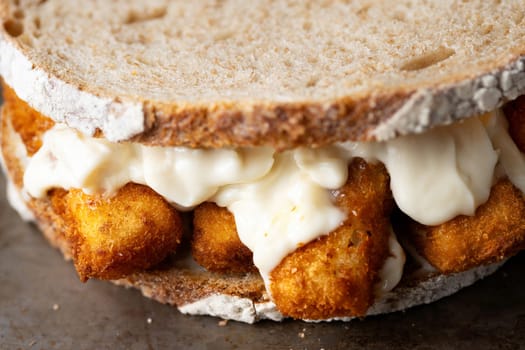 close up of rustic golden english fish fingers sandwich