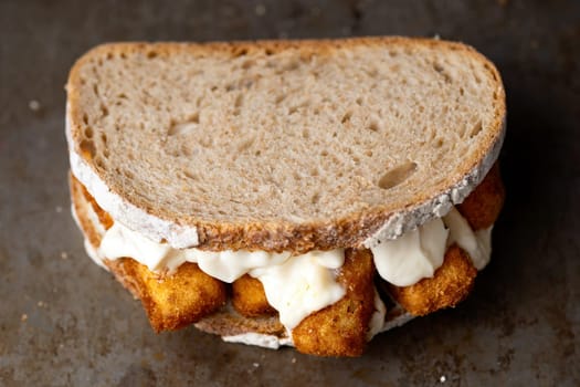 close up of rustic golden english fish fingers sandwich