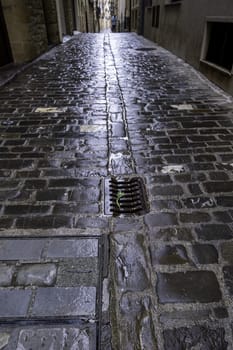 Wet stone street in old town, construction and architecture