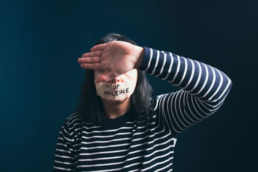 Women violence and abused concept. Stop domestic violence against women and human trafficking.Woman with tape on mouth and stop violence text