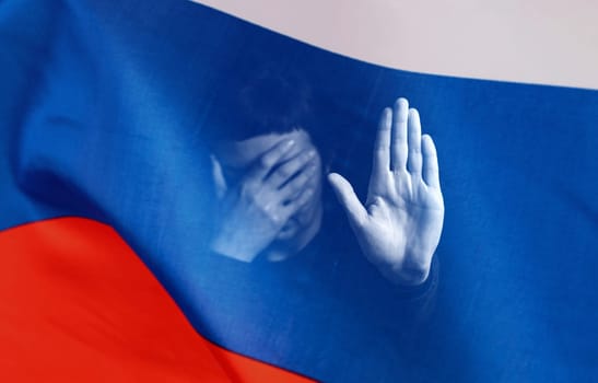 War between Russia and Ukraine. Woman with sad sight, Stop text over Russian flag.