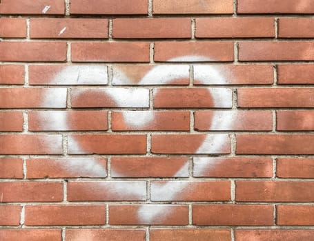 White heart painted on red brick wall. Love concept.