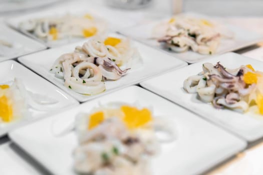 Fresh squid fish dishes, ready to be served to guests. Wedding, appetizers.