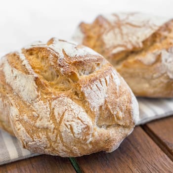 Bread with golden crust on wooden plank . Fresh homemade bread.