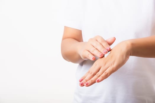 Closeup young Asian woman applying lotion cosmetic moisturizer cream on her behind the palm skin hand, studio shot isolated on white background, Healthcare medical and hygiene skin body care concept