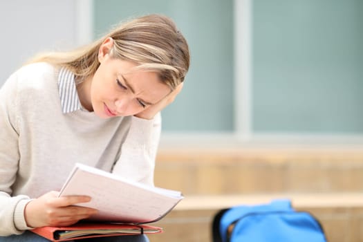 Concentrated student reading notes studying on campus