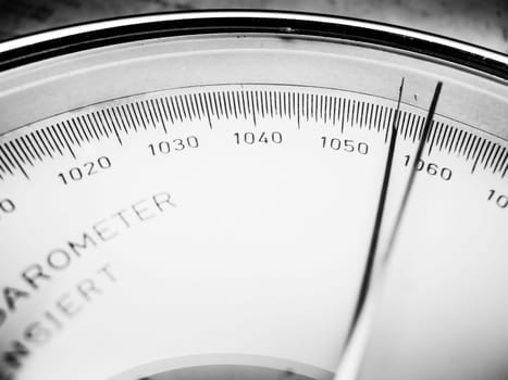 Close-up view of the scale with the pointer on the right of an analogue manual barometer monochrome.