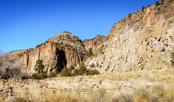 A view of the main cliff of Bandelier National Monument showing cave dwellings and remnants of Tyuonyi Pueblo