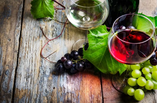Wine glasses and grape on rustic wooden table