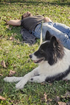Man laying in the grass with his dog