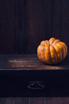 Thanksgiving concept. Orange pumpkin on rustic table with copyspace.
