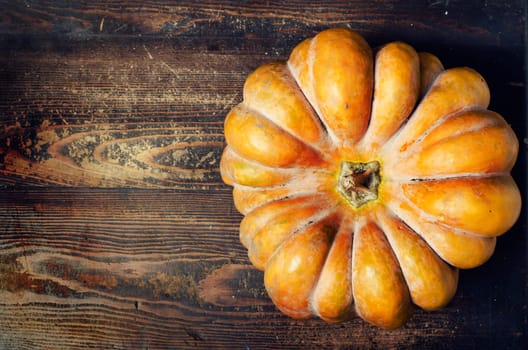 Thanksgiving concept. Orange pumpkin on rustic table with copyspace.