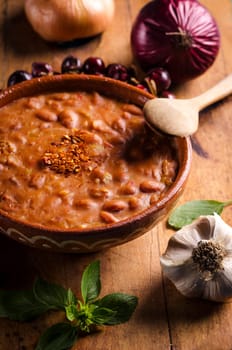 Spicy baked beans in traditional clay bowl