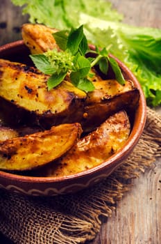 Spicy roasted potatoes in traditional clay bowl