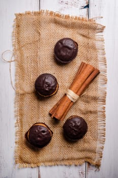 Chocolate muffins with cinnamon on wooden table