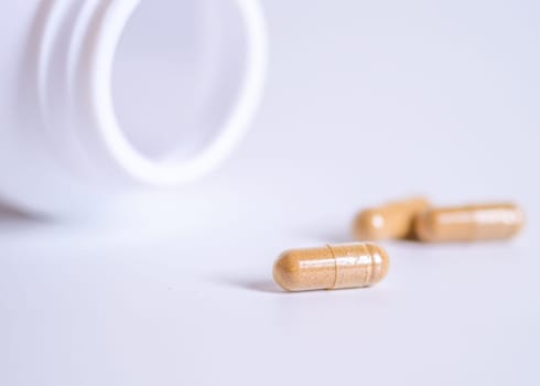 Pill spilling out of a bottle blurred background, Medicine capsule for health, Vitamin spilling out from bottle, Macro