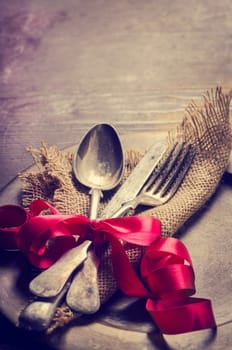 Vintage valentine table settings decorated with red ribbon. Image is filtered.