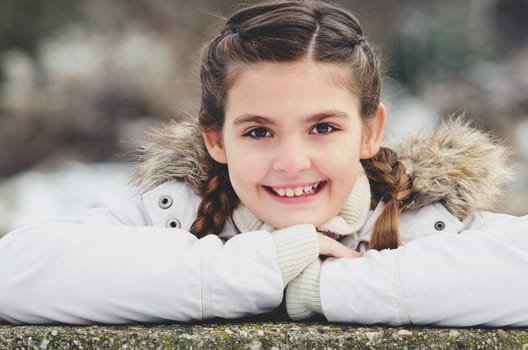 Portrait of young girl in winter jacket with fur.