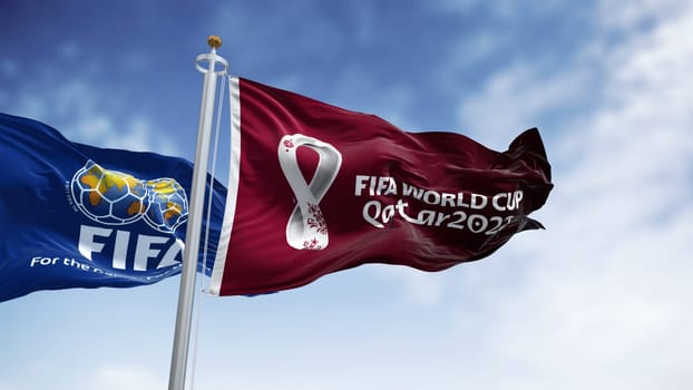Doha, Qatar, January 2022: Flags with FIFA and Qatar 2022 World Cup logo waving in the wind. The event is scheduled in Qatar from 21 November to 18 December 2022