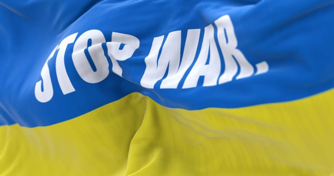 Detail of the national flag of Ukraine with the "stop war"" text waving in the wind . Democracy and politics. Patriotism. Selective focus. Seamless Slow motion"
