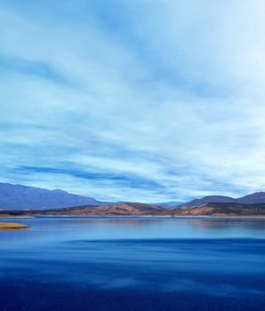 Mountain and reflections of Mountain in Roosevelt lake Central Arizona