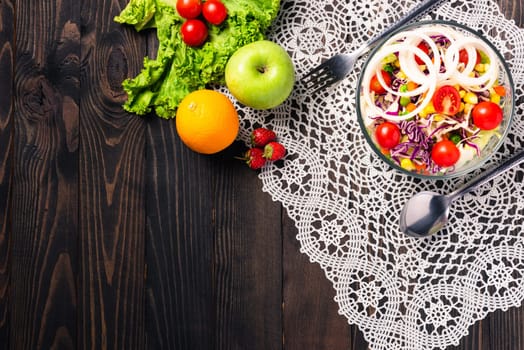 Top view of the healthy colorful fresh salad bowl with quinoa, tomatoes, and mixed greens vegetable in a dish on black wooden background, Health snack food