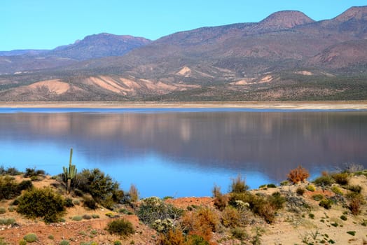 Mountain and reflections of Mountain in Roosevelt lake Central Arizona
