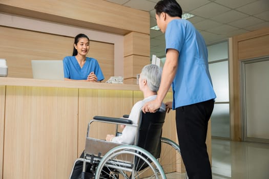 Patient elderly sit on wheelchair meet and talking with nurse or staff at front counter in of the hospital, healthcare reception service treatment process concept