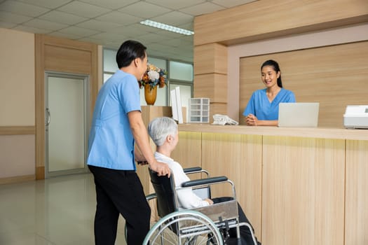 Patient elderly sit on wheelchair meet and talking with nurse or staff at front counter in of the hospital, healthcare reception service treatment process concept