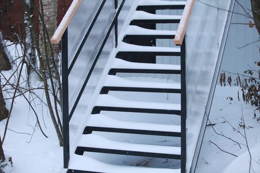 winter, the steps of the stairs are covered with white pure snow