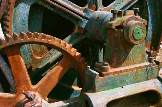 Abandoned Rusty mining iron wheel with teeth and gears natural background