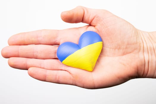 Heart shaped flag of Ukraine in female hands. The concept of solidarity with the citizens of Ukraine.