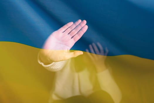 War between Russia and Ukraine. Woman with sad sight, Stop gesture over Ukraine flag.