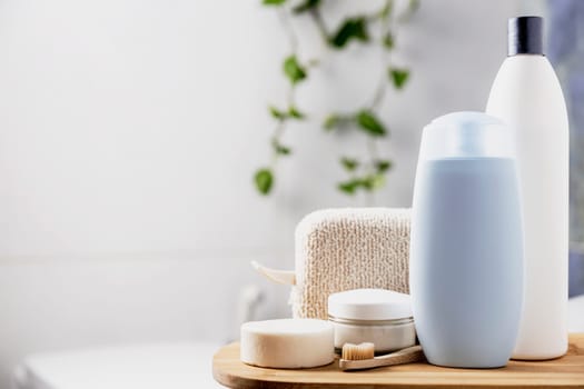 Preparation for hotel spa treatment or home bath procedure. Bathroom with accessories and cosmetics. Shampoo, shower gel, hair conditioner, washcloth, soap, tooth brush, cream glass bottle, white soap