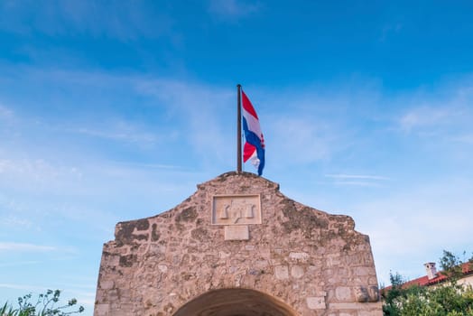 Croatian flag and gate tower to historic town Nin, Dalmatia, Croatia