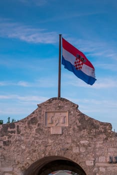 Croatian flag and gate tower to historic town Nin, Dalmatia, Croatia