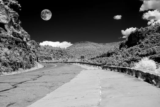 Infrared monochrome desert full moon over the southwestern USA Sonora desert Arizona and mountain road