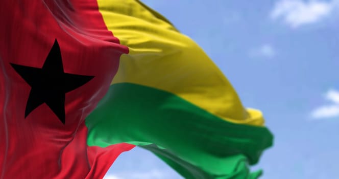 Detail of the national flag of Guinea-Bissau waving in the wind on a clear day. Guinea-Bissau is a country in West Africa. Selective focus.