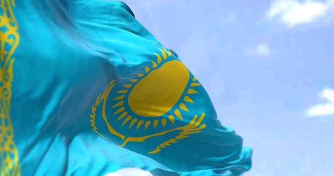 Detail of the national flag of Kazakhstan waving in the wind on a clear day. Kazakhstan is a transcontinental country located mainly in Central Asia, and partly in Eastern Europe. Selective focus.