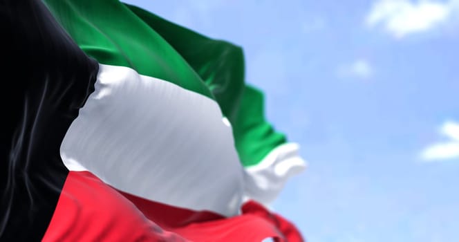 Detail of the national flag of Kuwait waving in the wind on a clear day. Kuwait is a country in Western Asia. Selective focus.