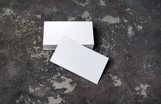 Blank white business cards on concrete background. Mockup for branding identity. Template for graphic designers portfolios.