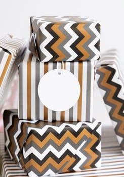 Present with blank gift tag close up. Gift boxes wrapped in Striped and chevron geometric paper. Christmas, New Year, Birthday, Anniversary label mockup