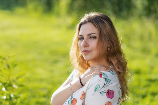 Atractive beautiful  young woman is posing outdoors. Horizontally.