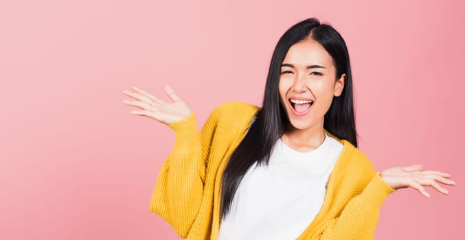 Happy Asian portrait beautiful cute young woman standing winning and surprised excited screaming open mouth raise hands, studio shot isolated pink background, Thai female wow with copy space