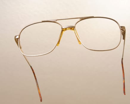 Modern medical eyeglasses isolated on a tan background