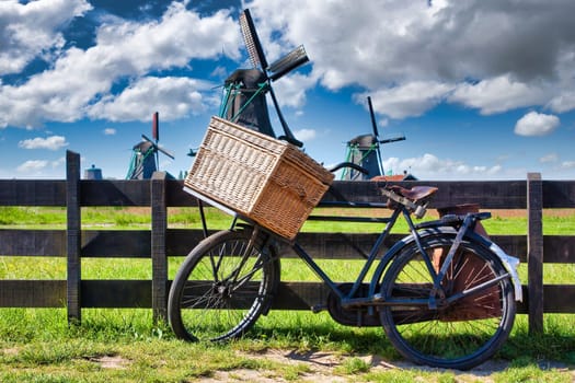 Bicycle with windmill and blue sky background. Scenic countryside landscape close to Amsterdam in Netherlands.