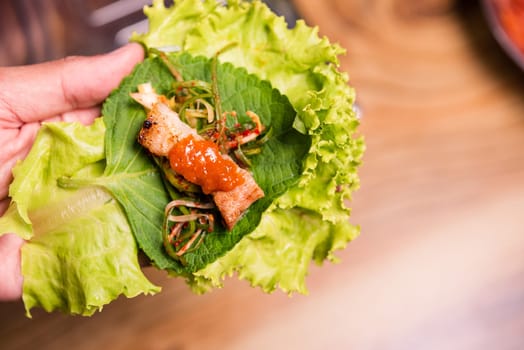 BBQ korean grill buffet. grilling meat wrap green vegetable leaf for eat at restaurant, korean barbeque style, Healthy food or Unhealthy food concept