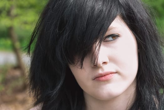 Gothic emo girl looking away, close-up of her face, black hair, horizontal